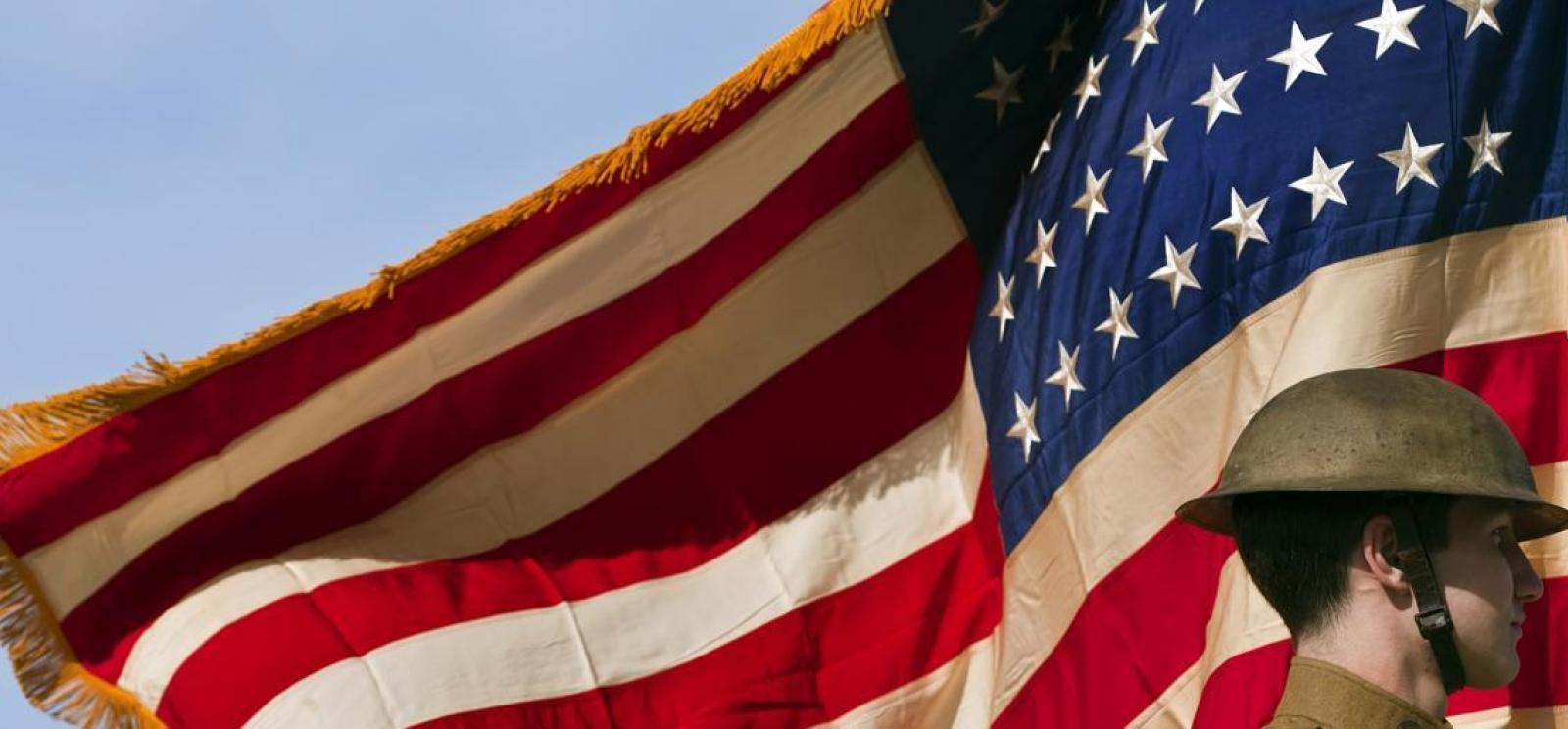 a man standing in front of a flag