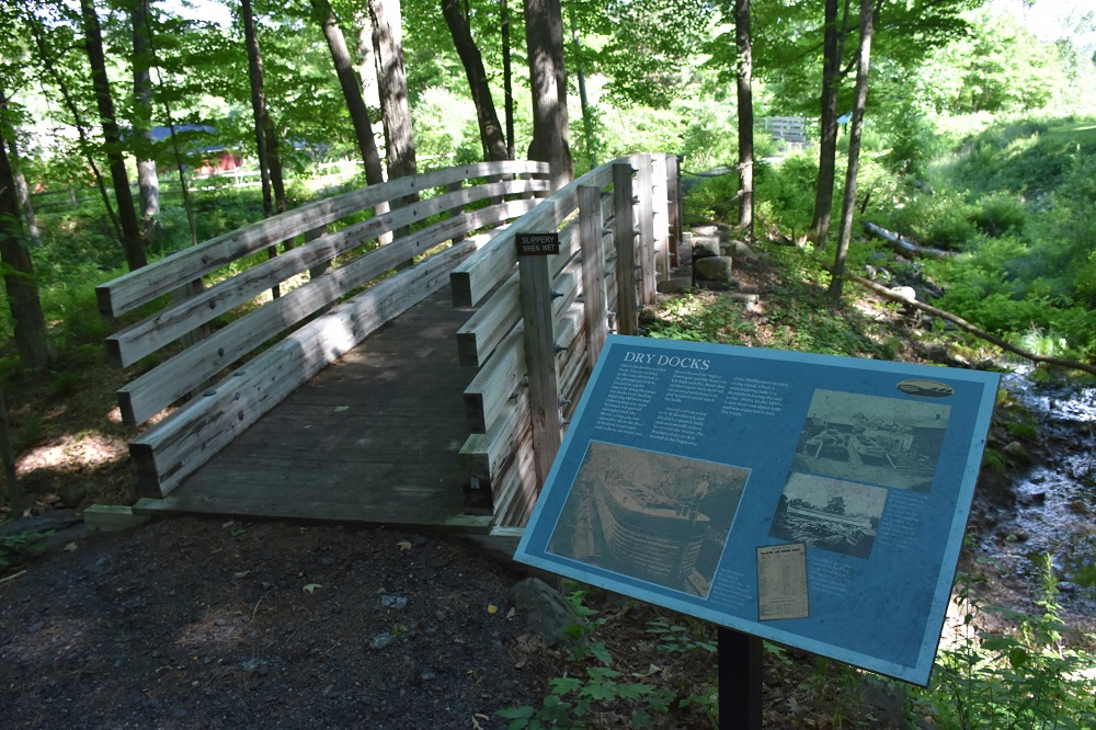 an empty park bench next to a forest