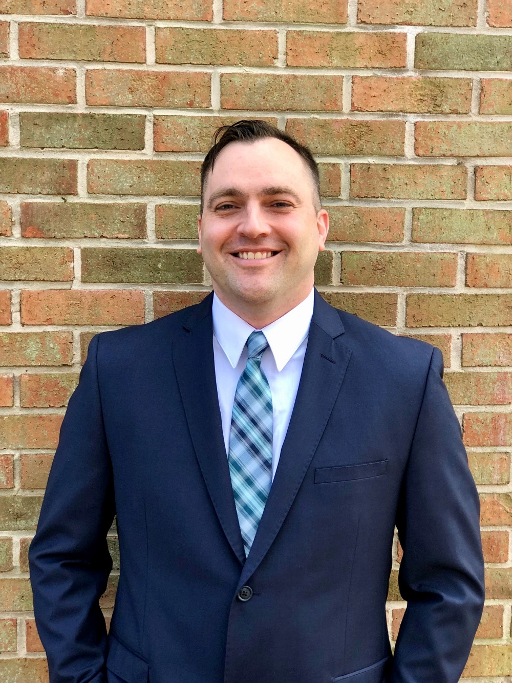 a man wearing a suit and tie smiling at the camera