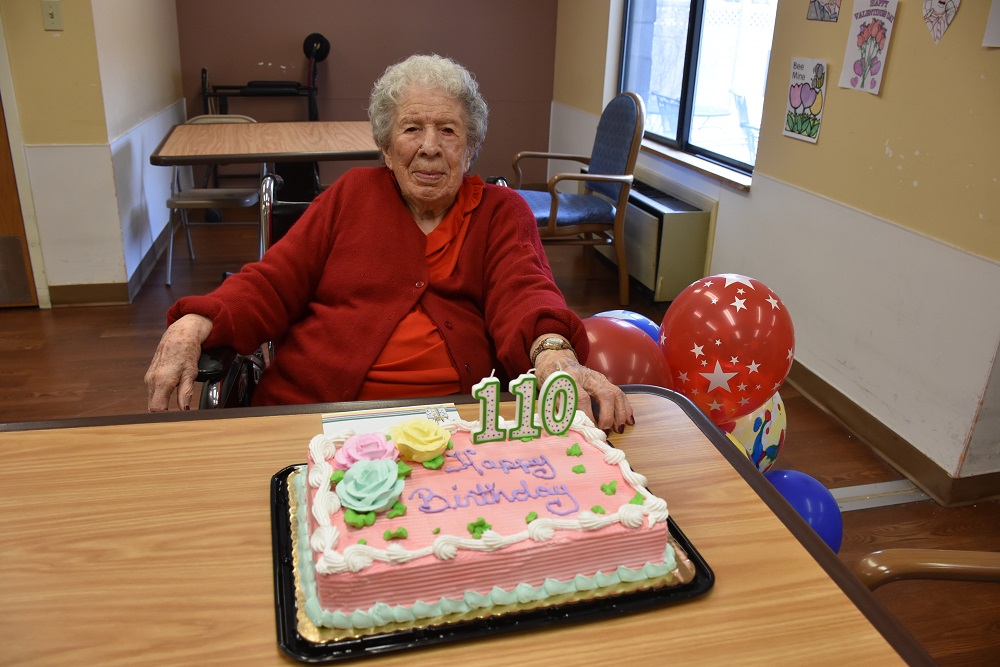 a person sitting at a table with a birthday cake