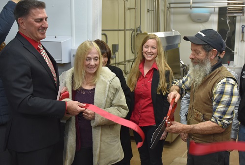 a group of people cutting a ribbon